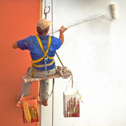 Commercial painter is painting a wall with a white paint