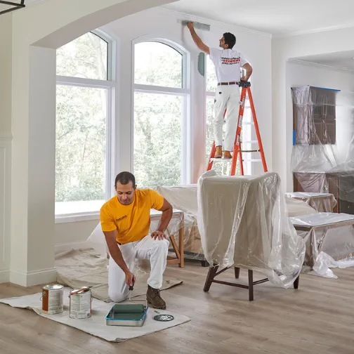 Two men are painting interior walls