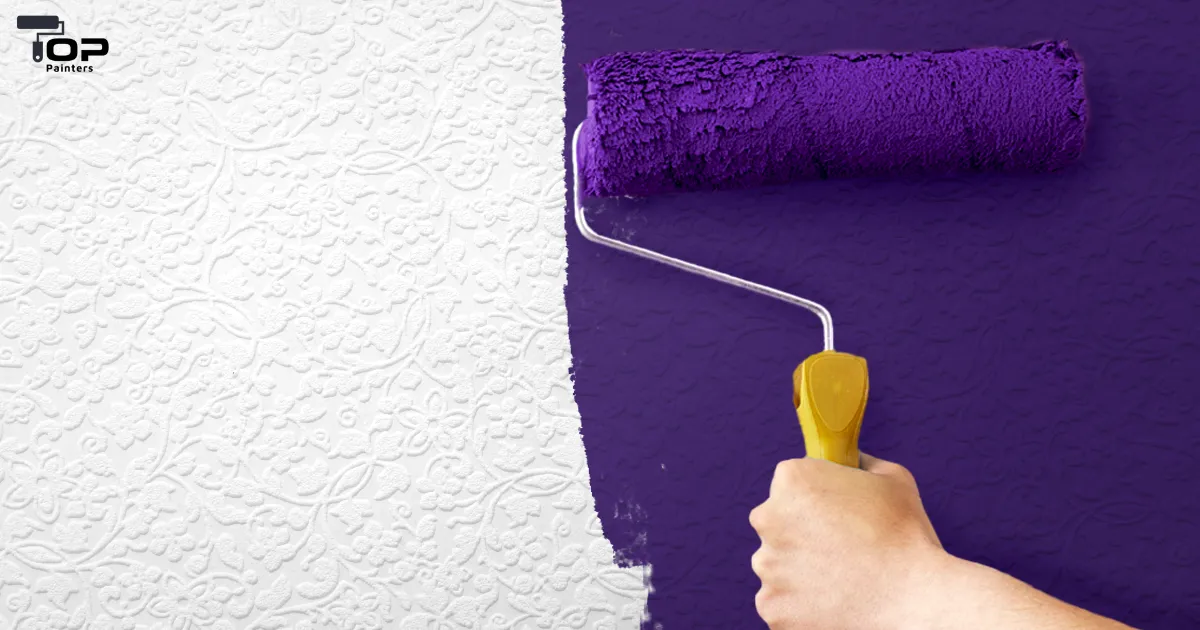 Using a roller and purple paint to paint a building interior.